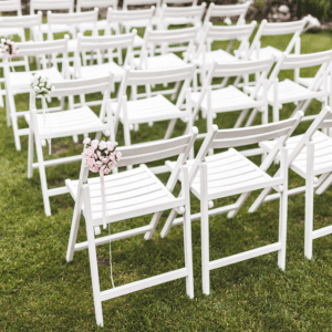 White chairs arranged for outdoor wedding ceremony.